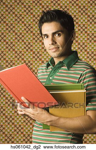 Stock Photo - young man holding  multicolored books.  fotosearch - search  stock photos,  pictures, wall  murals, images,  and photo clipart