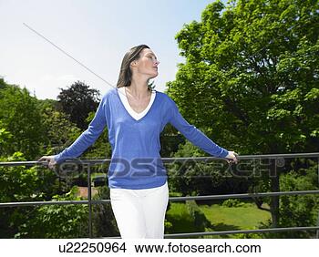 Stock Photo - woman enjoying 
the sun, on the 
terrace. fotosearch 
- search stock 
photos, pictures, 
wall murals, images, 
and photo clipart