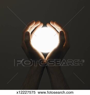 Stock Image of Hands holding orb of light, close-up, (digital ...