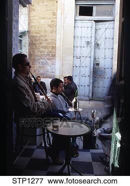 Picture - north africa tunisia  men sat smoking  a chicha in the  medina in tunis.  fotosearch - search  stock photos,  pictures, images,  and photo clipart